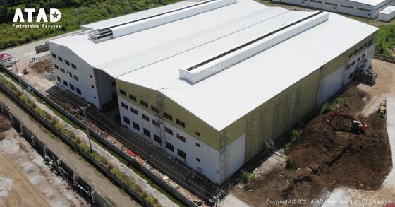Un grand immeuble de bureaux en acier préfabriqué avec un toit incliné et une fondation en béton